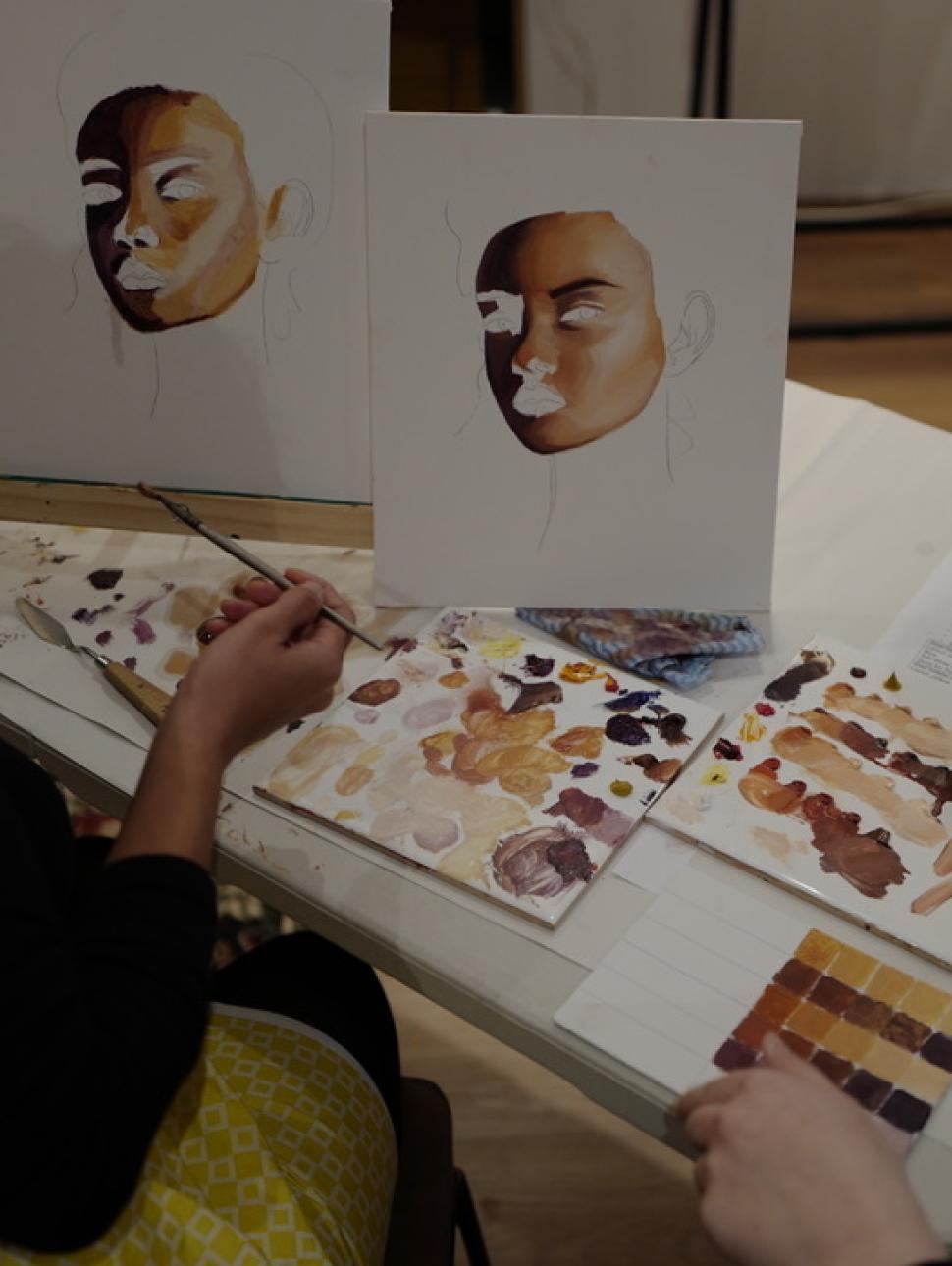 This image shows someone painting a portrait of someone.