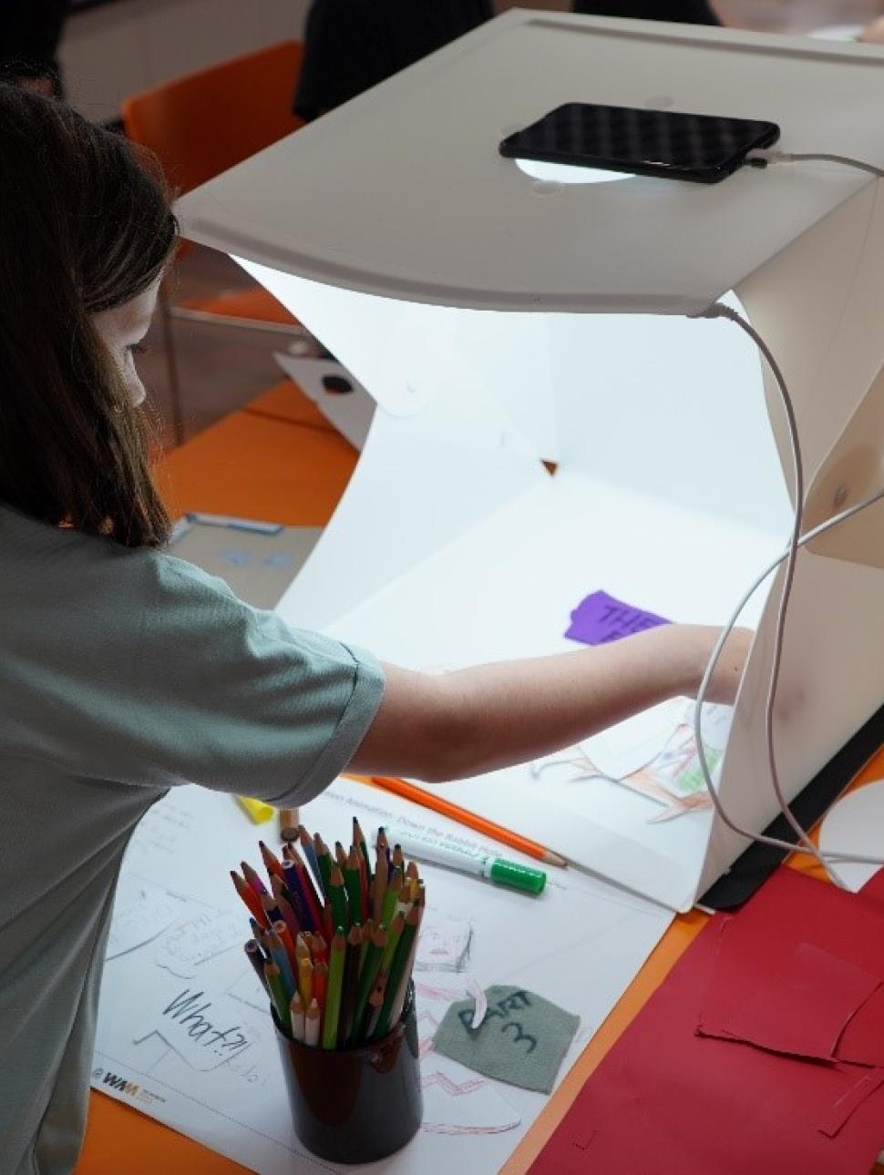 This image shows a girl setting up a scene for her stop animation film.