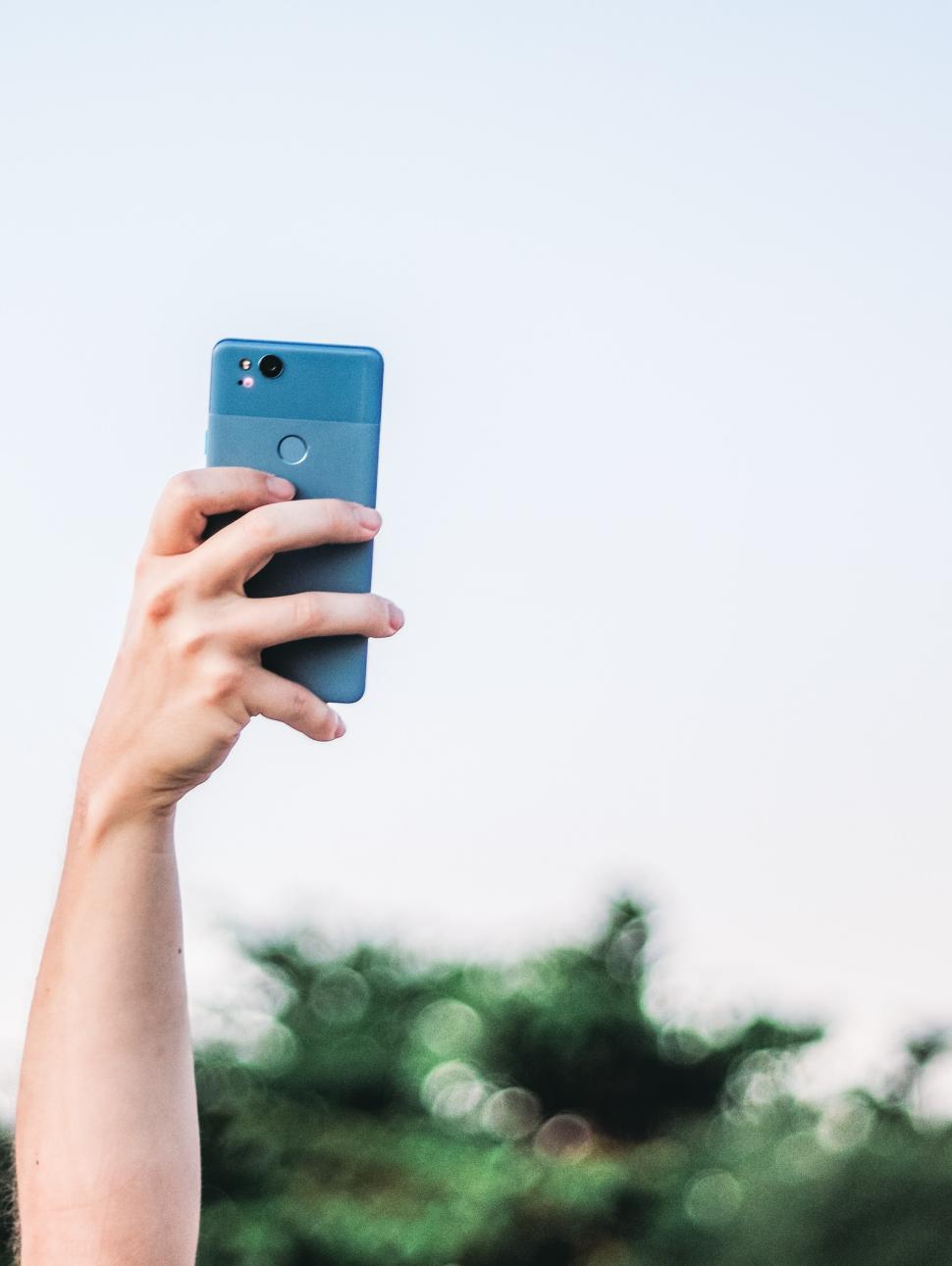Hand with a phone: taking picture at the concert or reaching for network connection