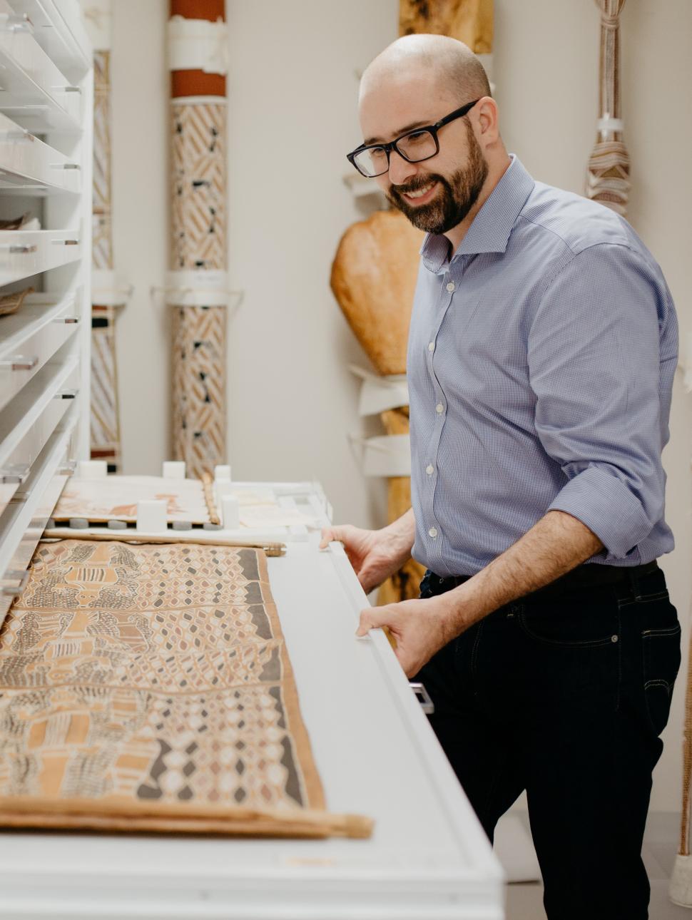 Henry stands at collections centre with artworks