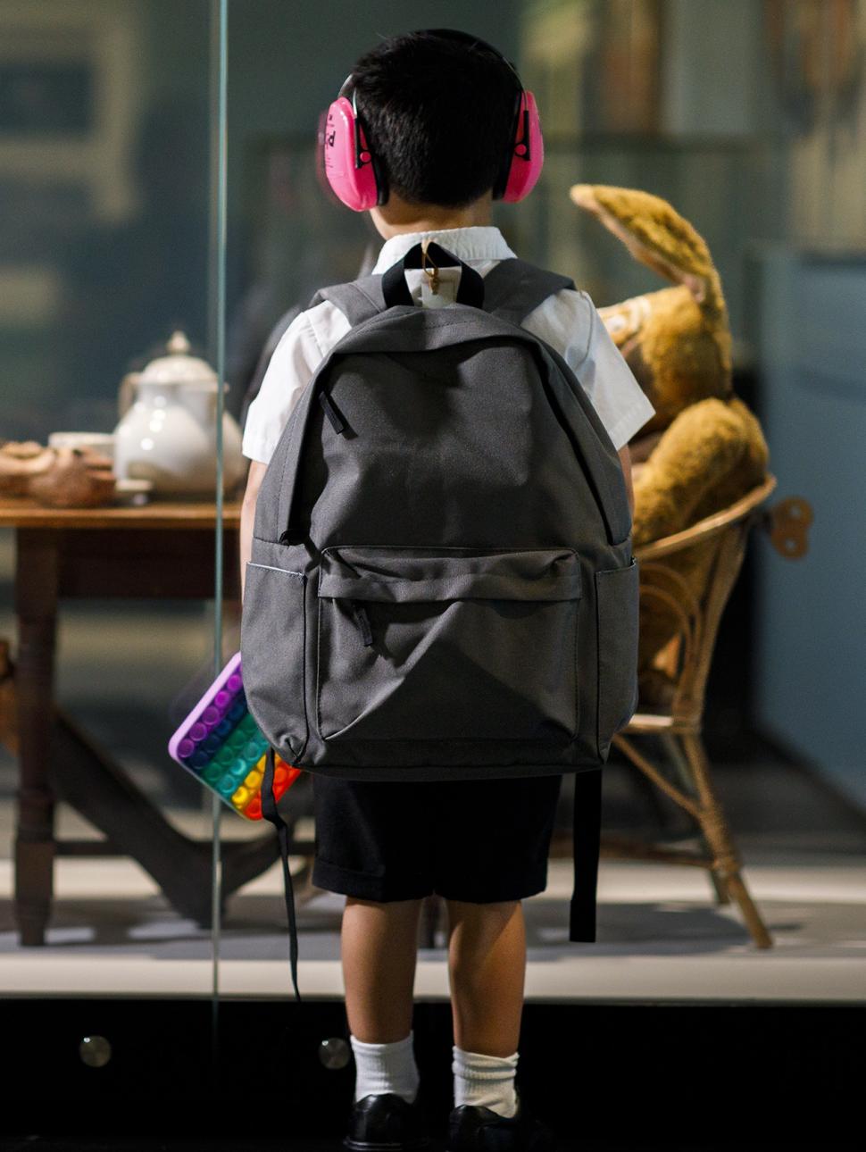 young child with backpack and ear defenders