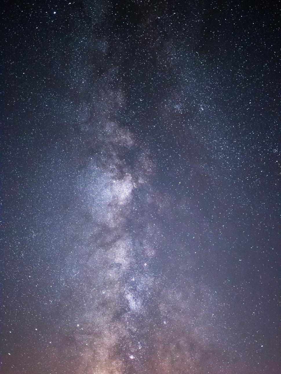 a dark sky with lots of stars clustered to make a line shape which is the milky way