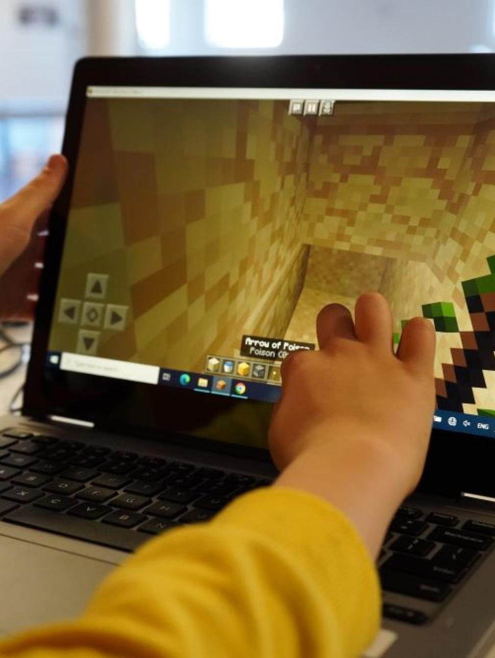This image shows a laptop computer screen displaying a Minecraft scene which the participant is constructing