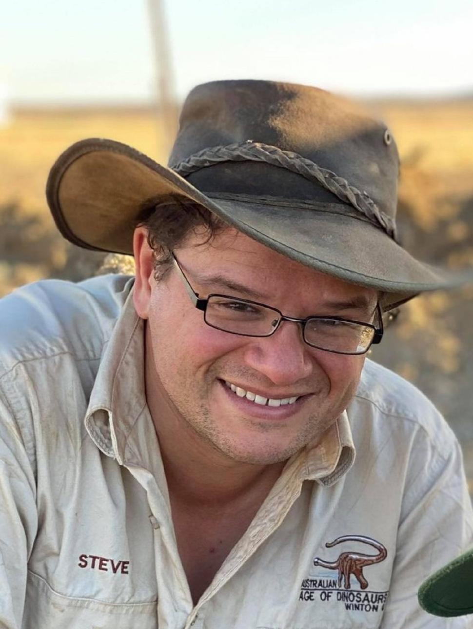 This is a close up image of scientist Stephen Poropat working in the field looking for fossils.