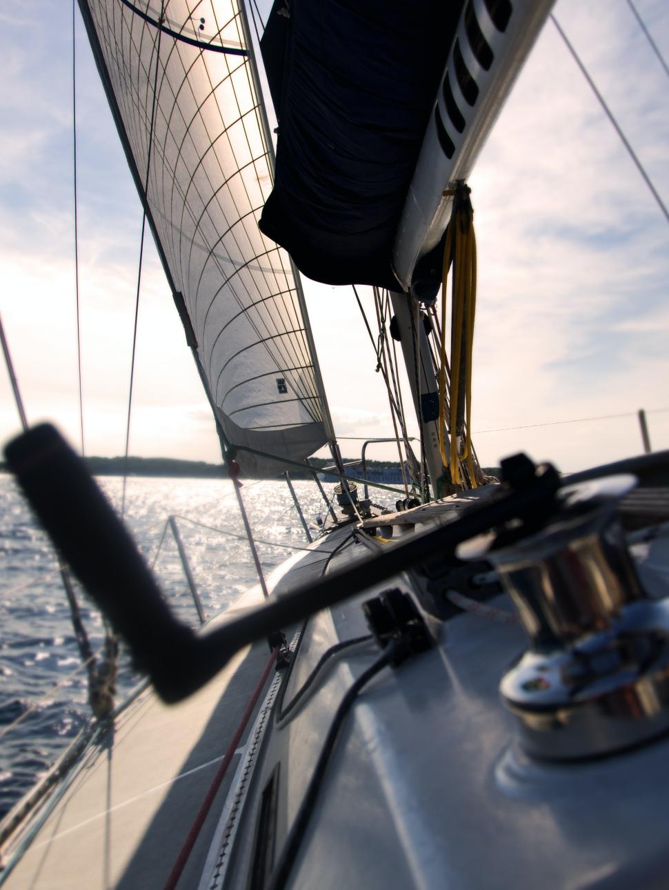 A view of the ocean from a yacht. the sails and yacht is visible on an incline on the horizon
