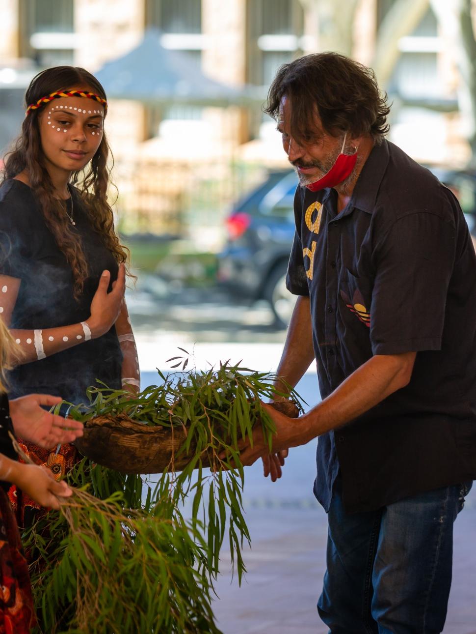 Derek with two girls at a smoking ceremony
