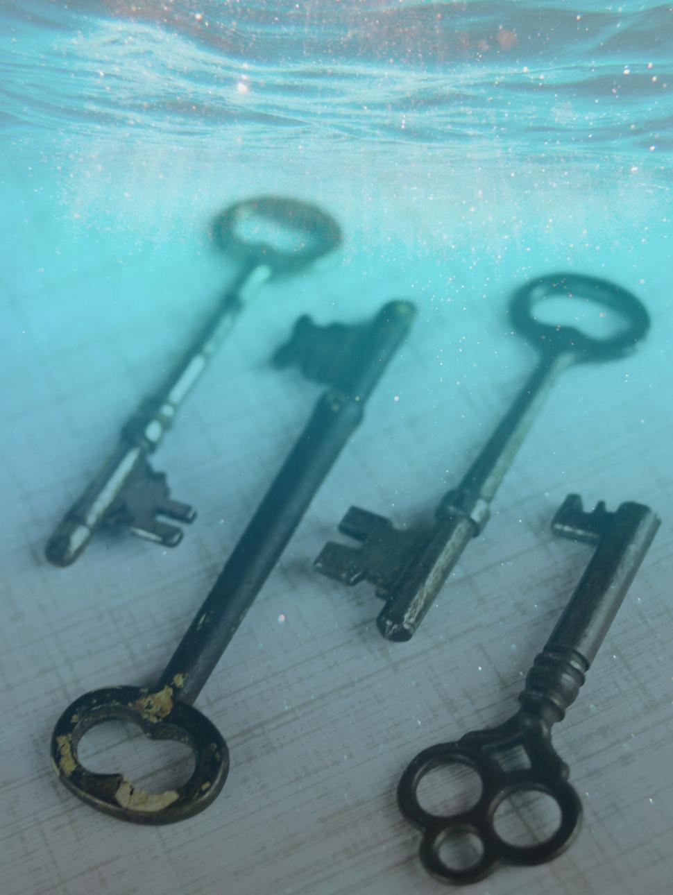 older style keys on a table with an underwater blue colour