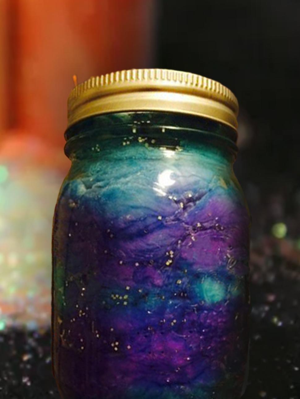 a close up of a jar with dark purples and black shiny liquid reminiscent of a space nebula