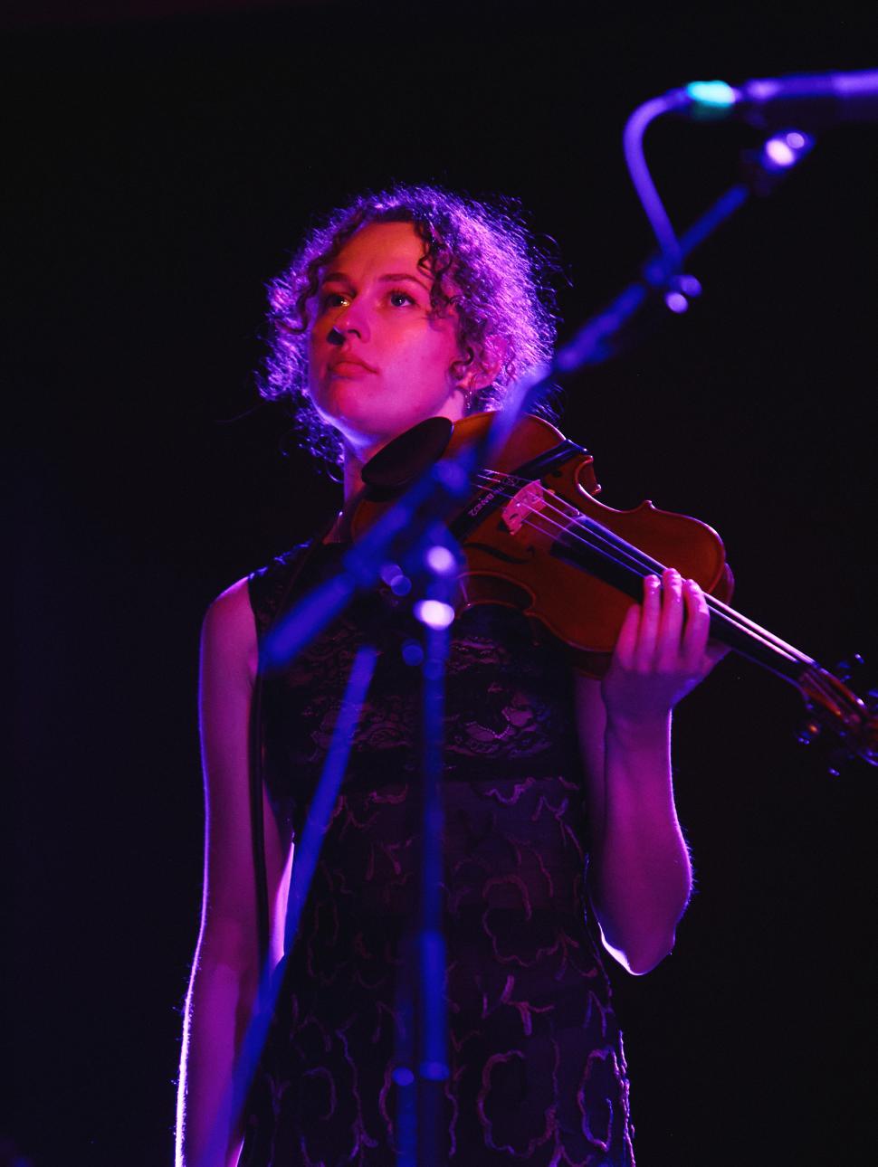 Image of Lily Tait, Melbourne Composer, in concert holding a violin.