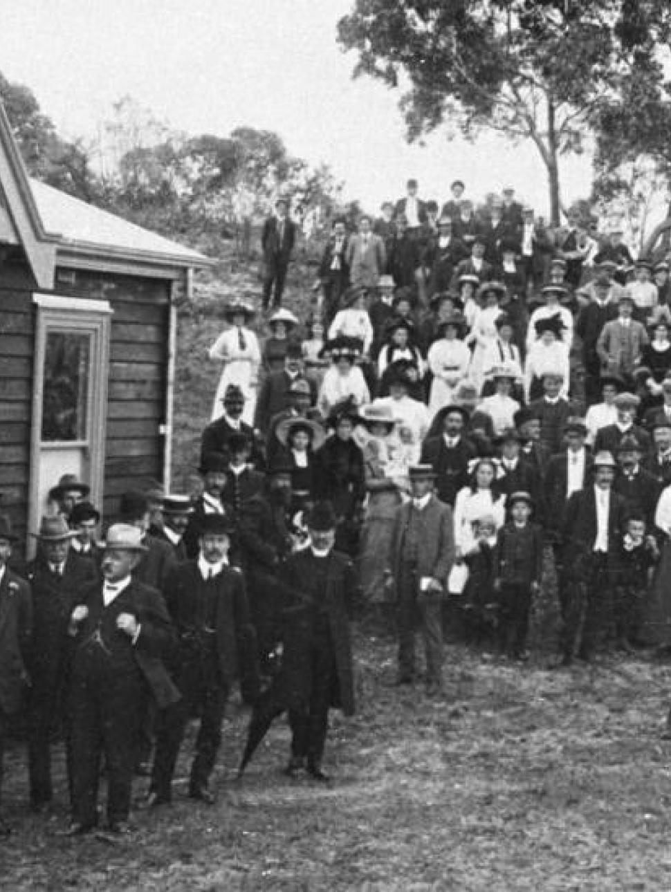 a black and white photo of a group of people gathered around a building