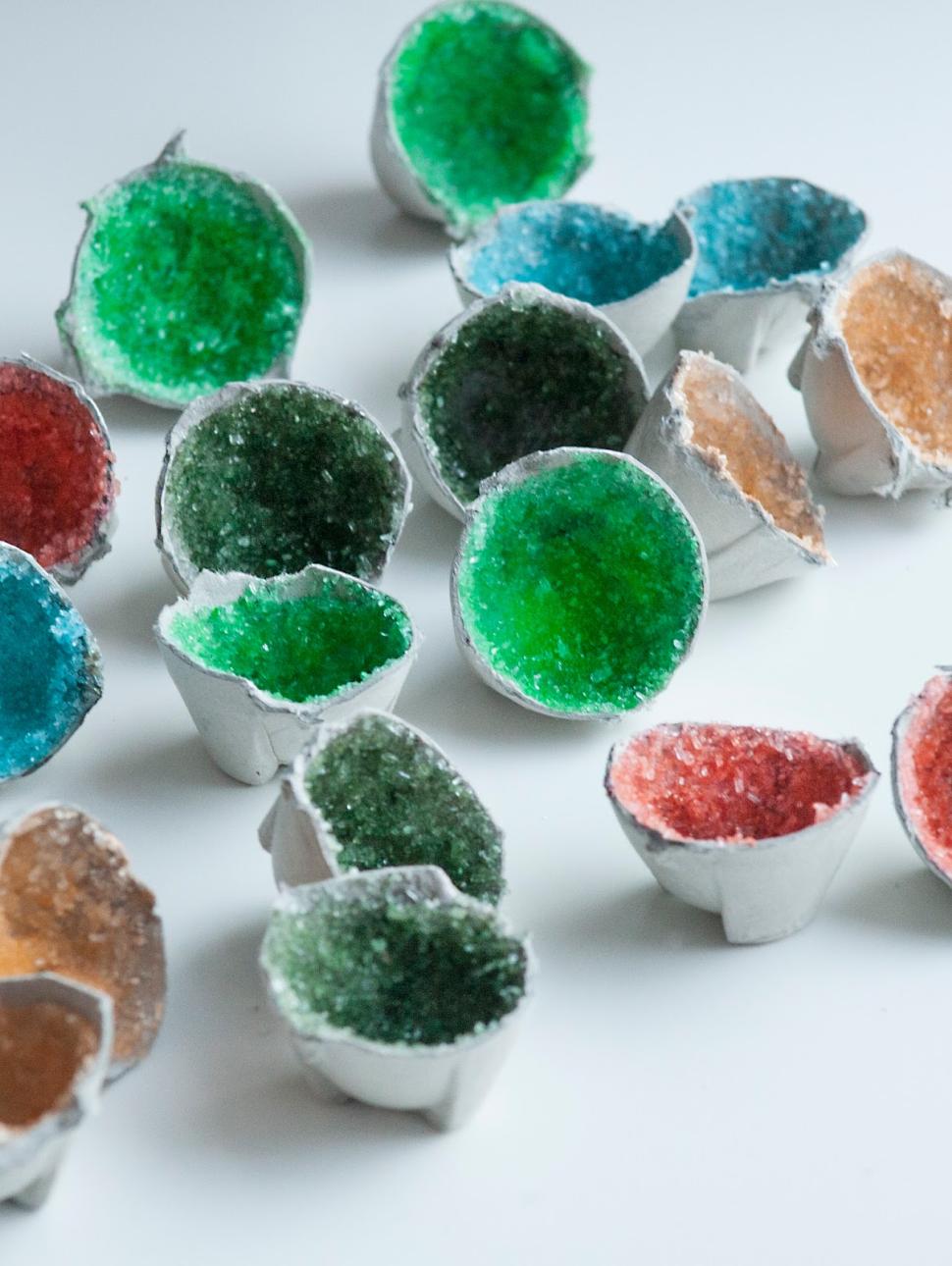 multicoloured half spheres on a white table. the insides of the spheres are coloured crystals