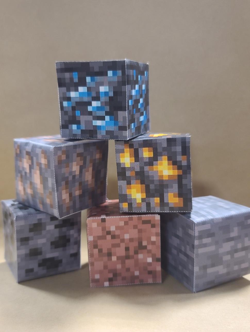 a stacked pile of paper blocks which are coloured in earthy colours pixellated as a popular video game.