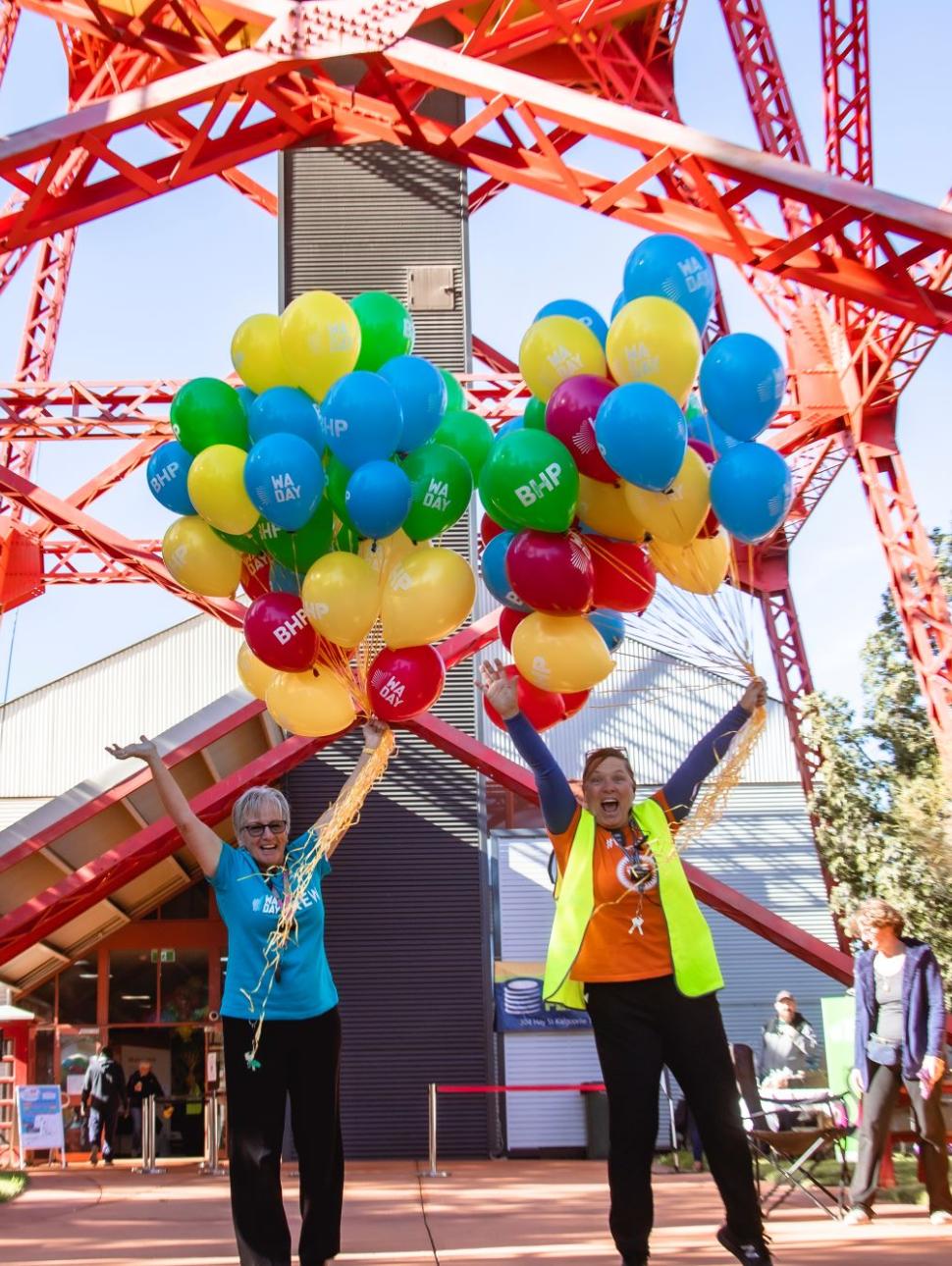 Two WA Day volunteers hold balloons in front of Museum of the Goldfields