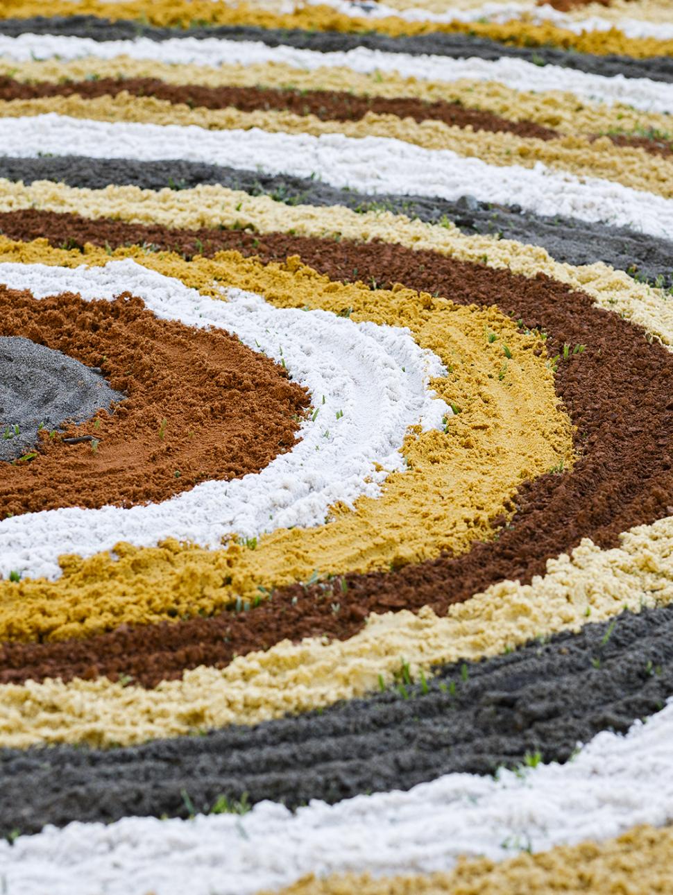 coloured sand circles making Aboriginal art