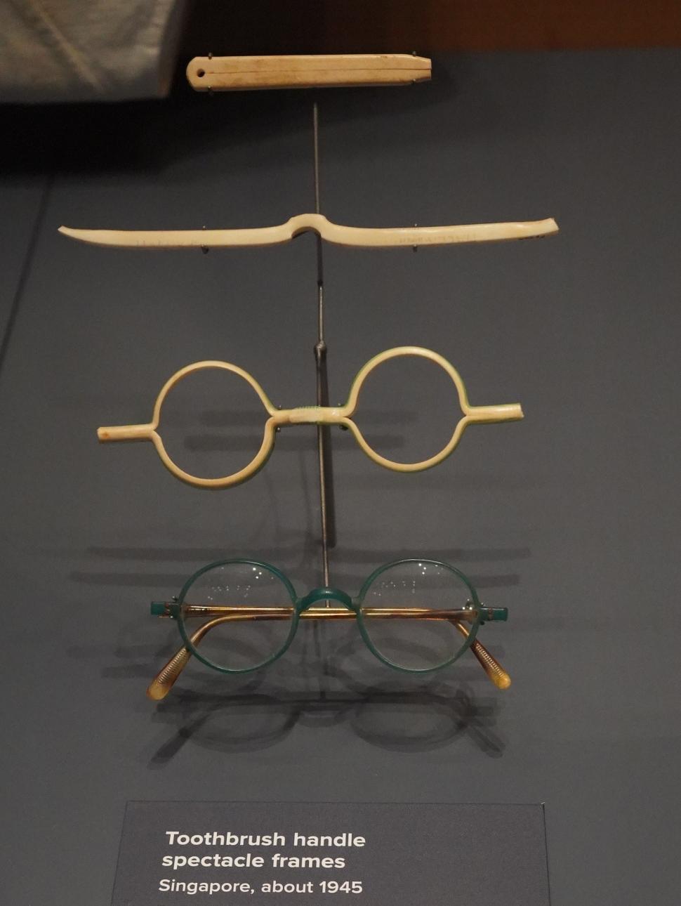 Image shows two pairs of  old, round spectacles made from toothbrush handles. 