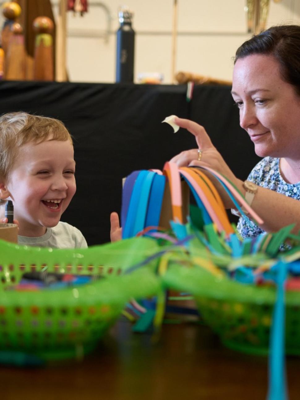 adult and child smiling and doing craft