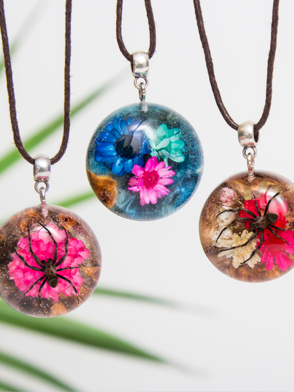 Three resin pendants with spider and flowers