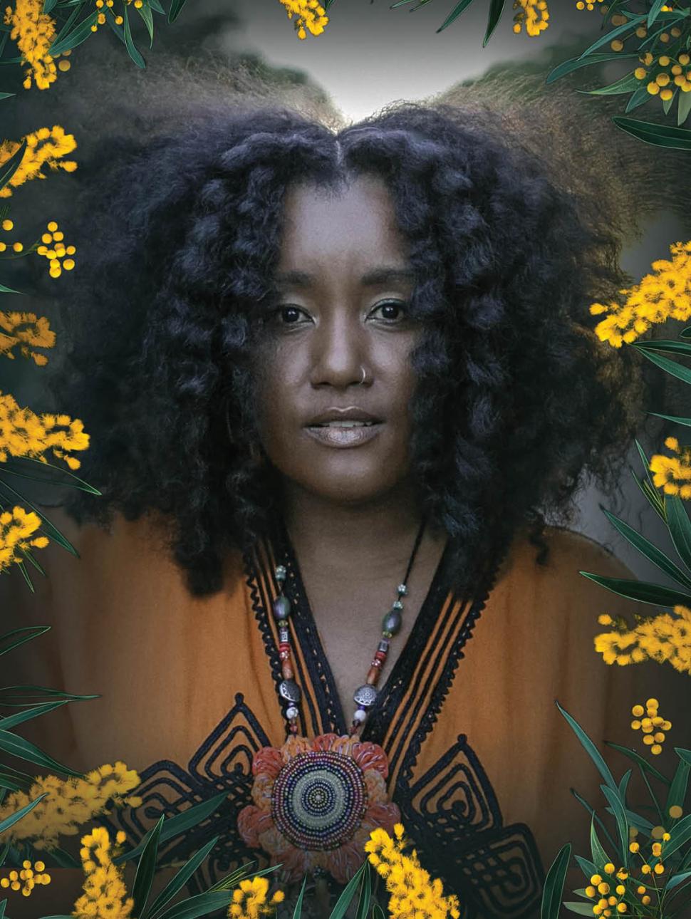 a woman wearing a colourful top stares at the camera