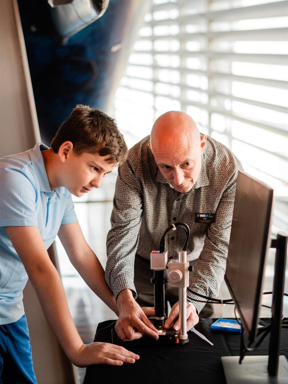 A student and WA Museum facilitator investigate marine life through a digital microscope in the WA Down Under education program.