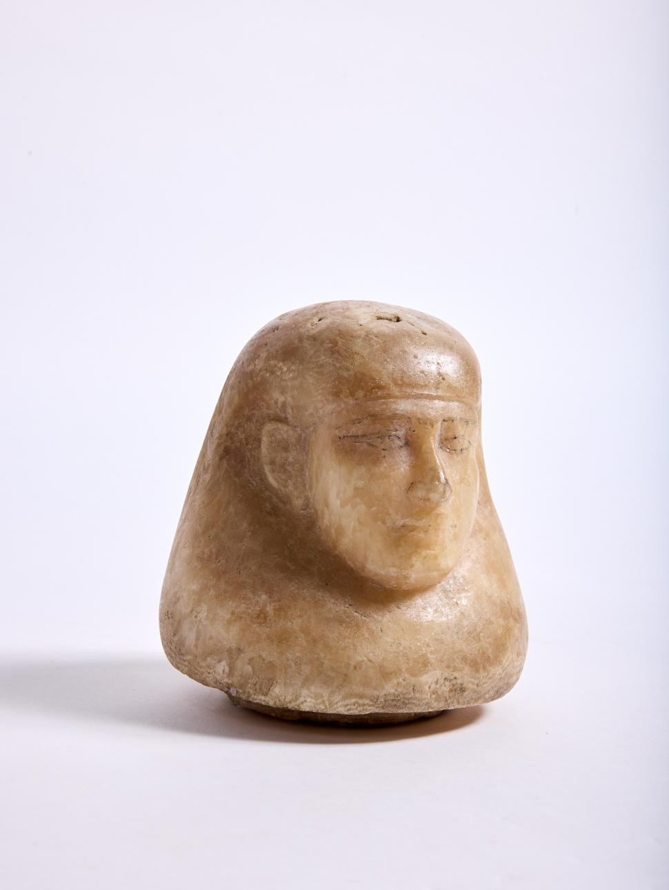 a sculpture of a human head with headdress as a jar lid sculpted from Egyptian alabaster 