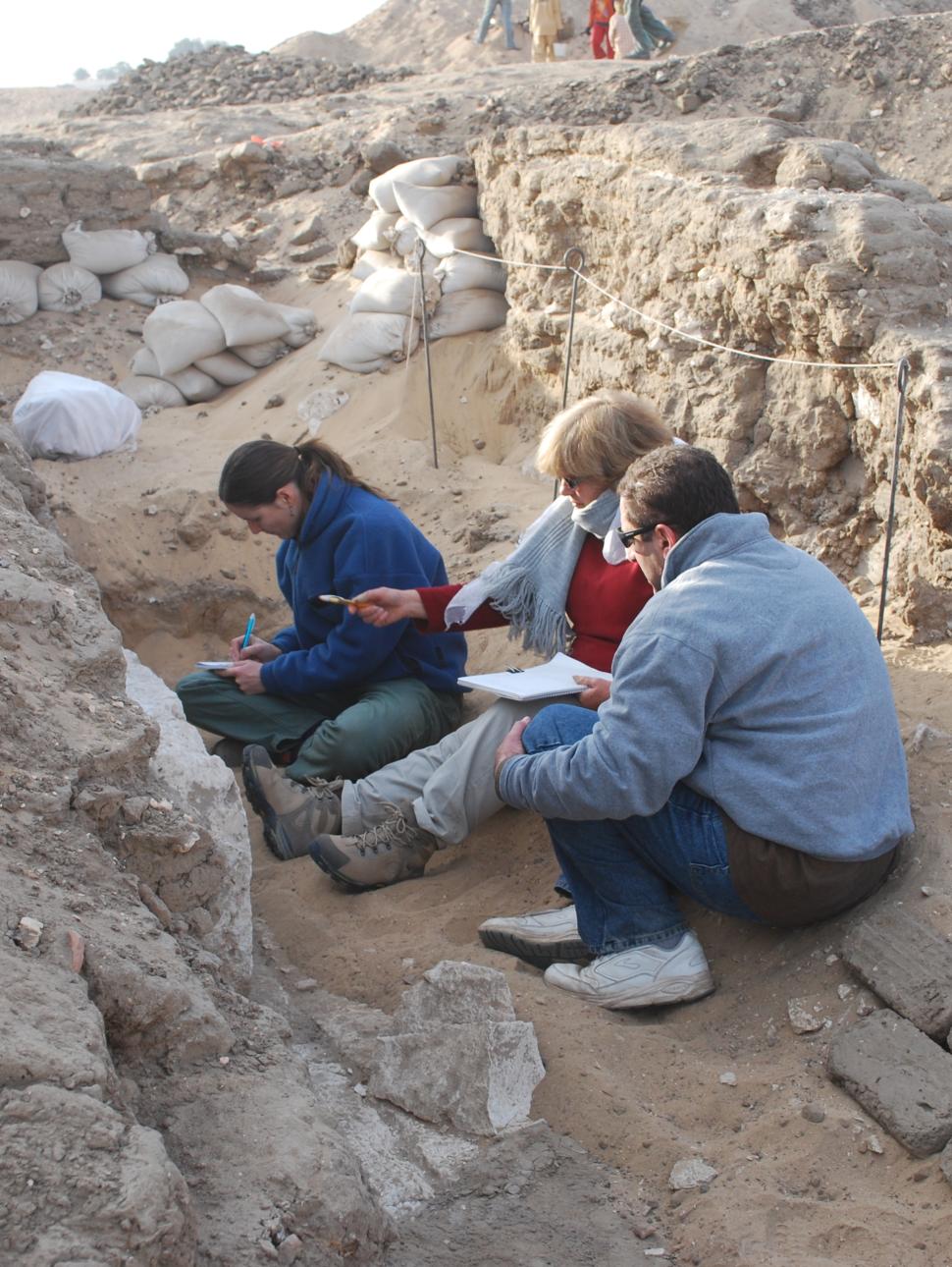 a group of people excavating a sandy tomb