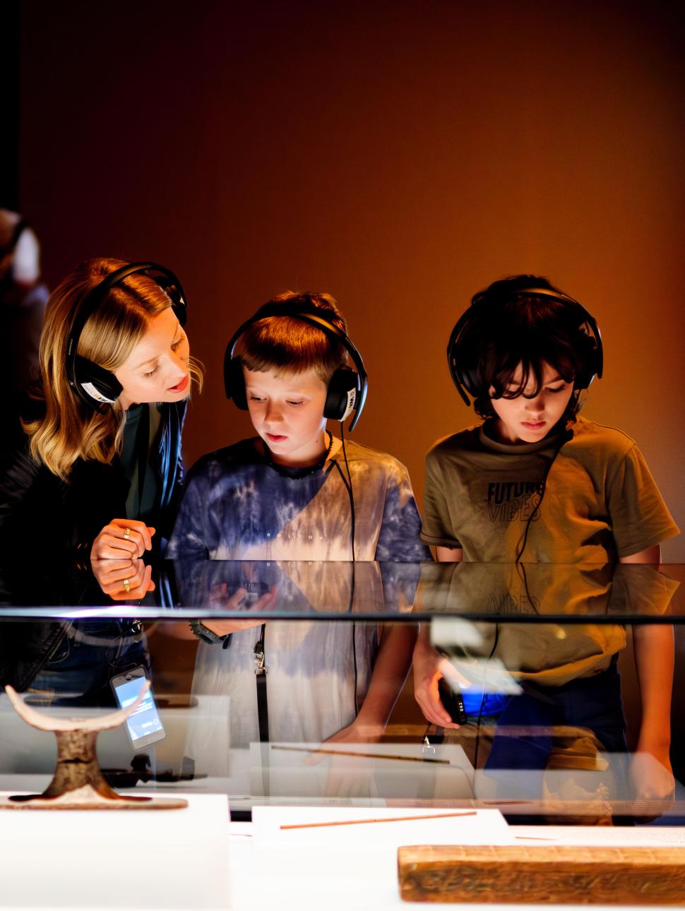 Children wearing headphones exploring an exhibition