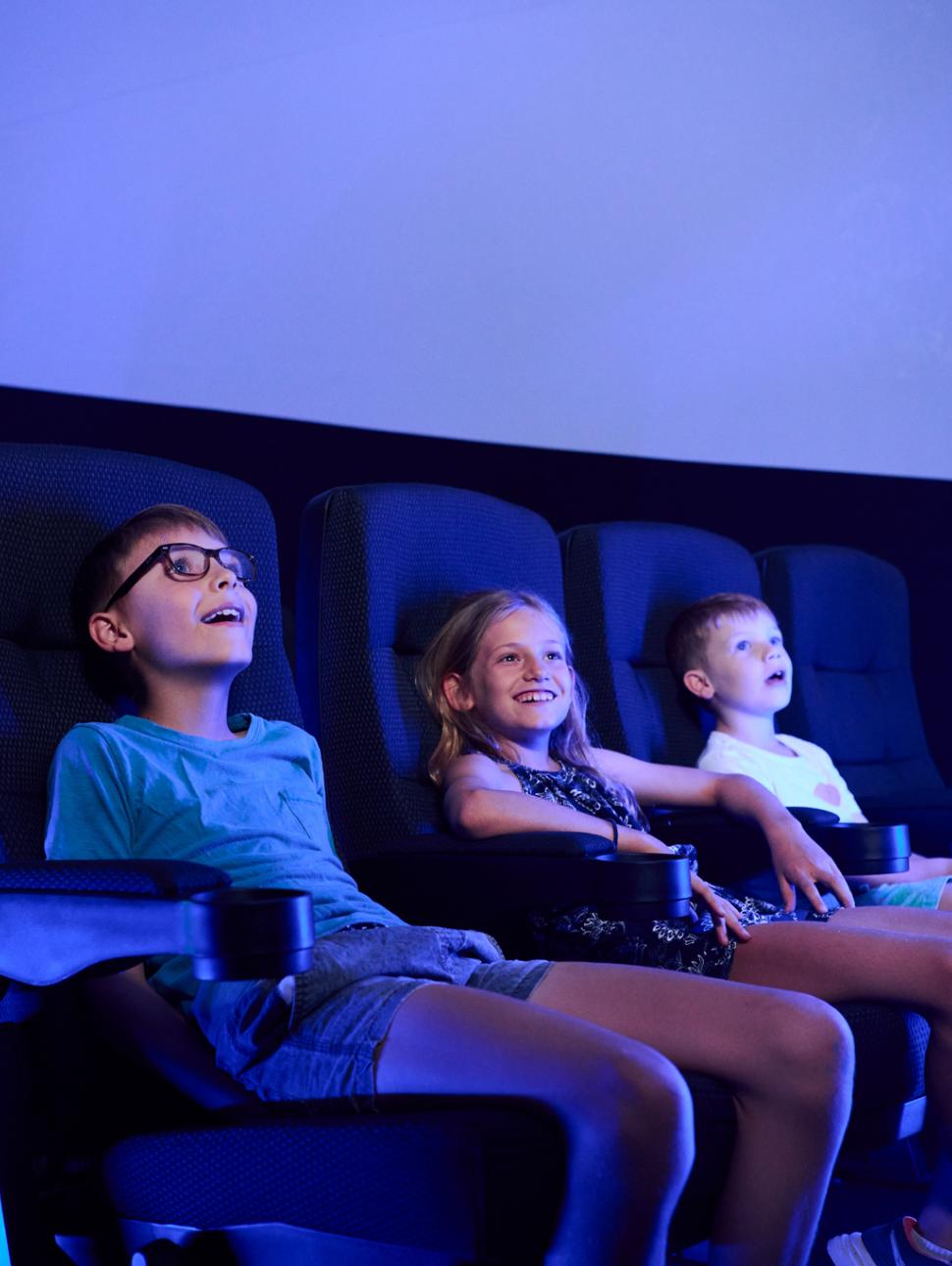 children sitting in theatre seats