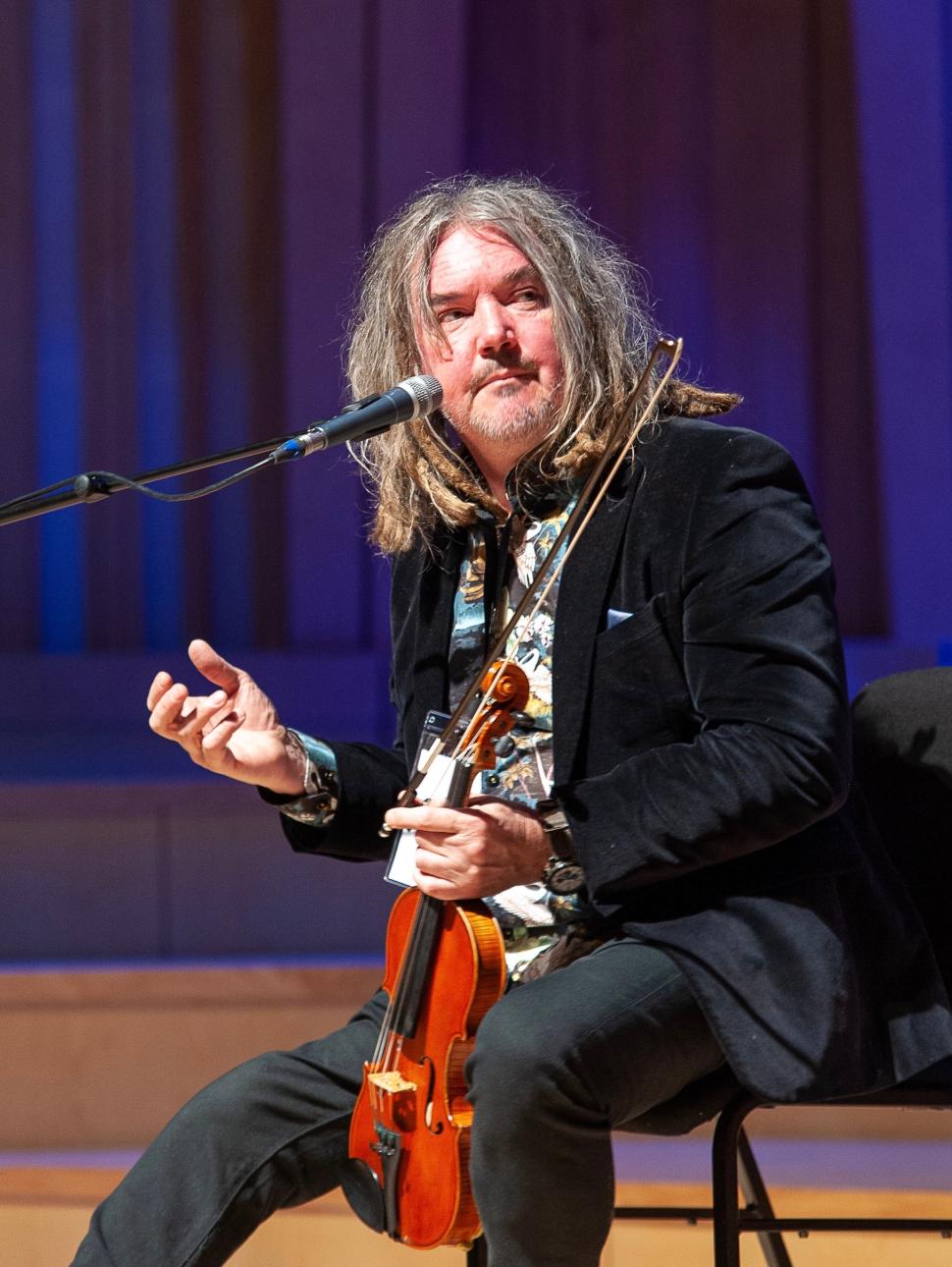 Rupert Guenther Sits holding a Violin