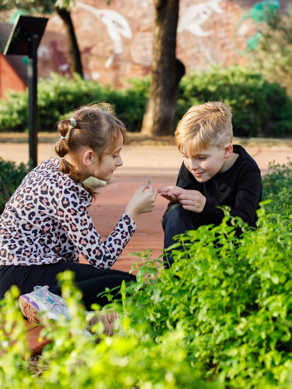 two children are looking at garden greenery