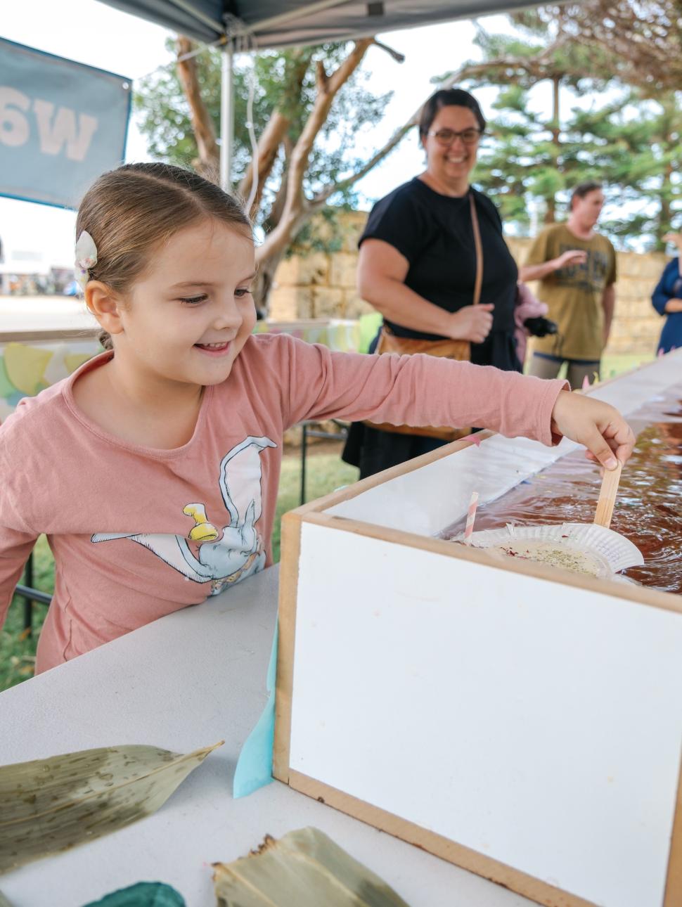 child interacting with a craft activity on a table 