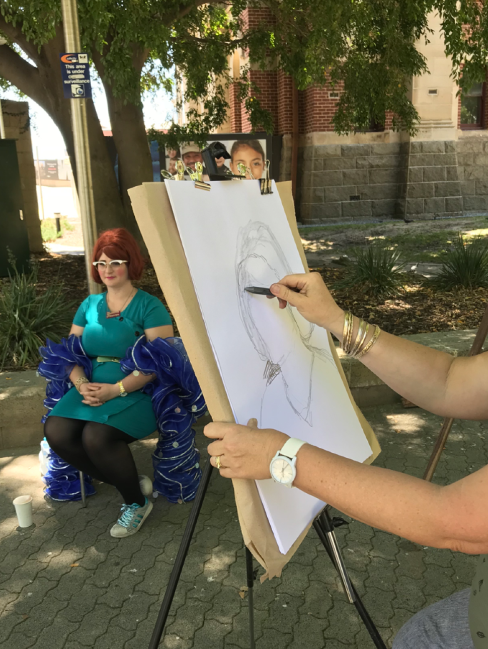  an artist drawing a portrait in an outside Venue