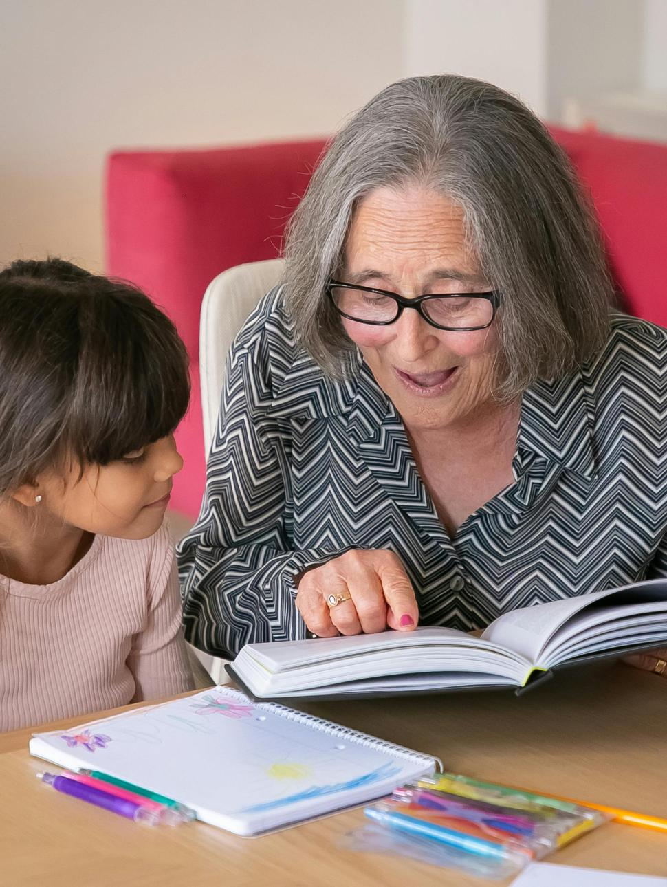 an older woman reads a book to a younger child