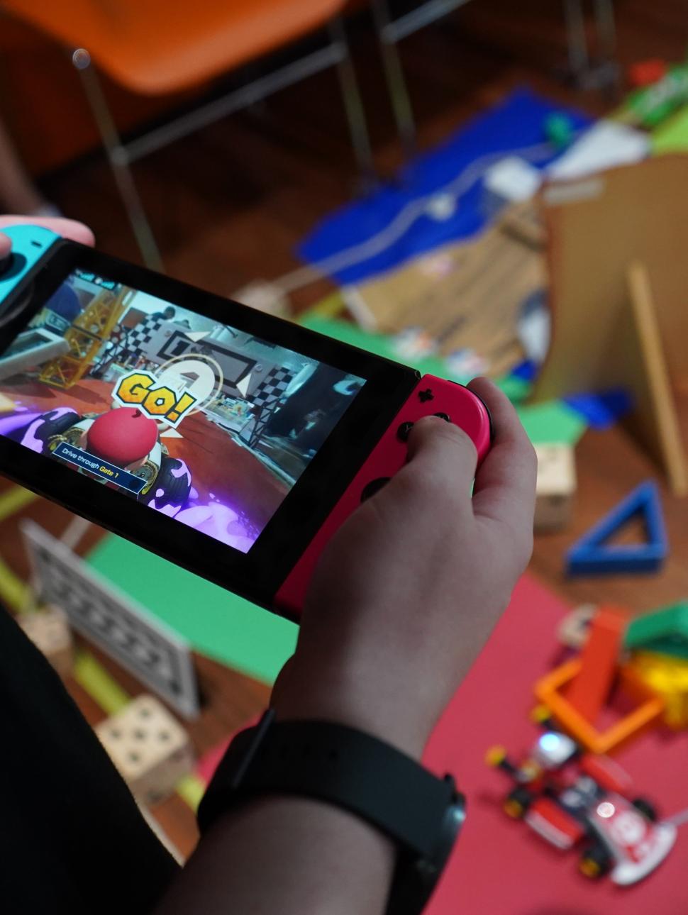Child holding a Nintendo Switch with Mario Kart on the screen