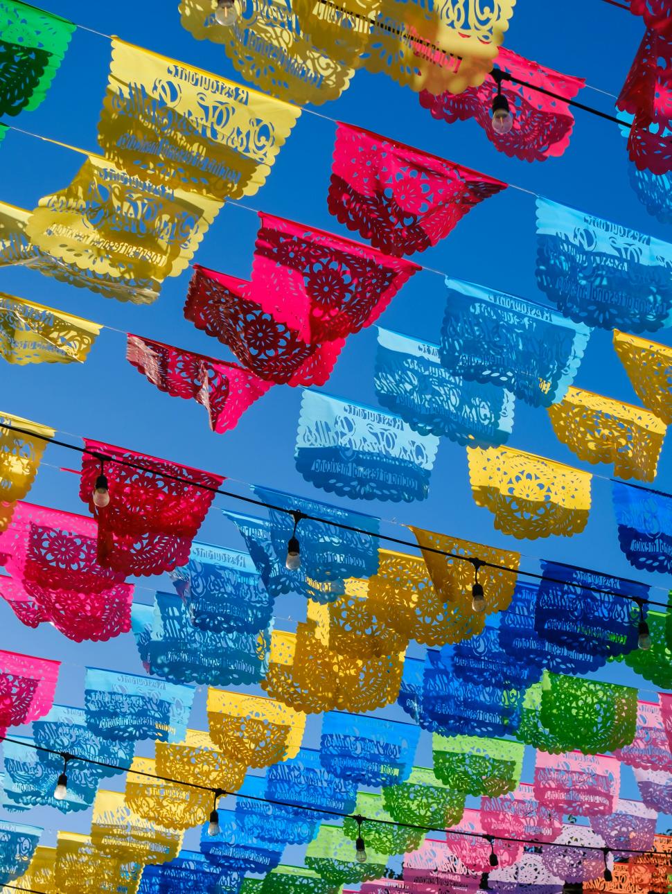 rows of different colour paper cutouts hung up outside 