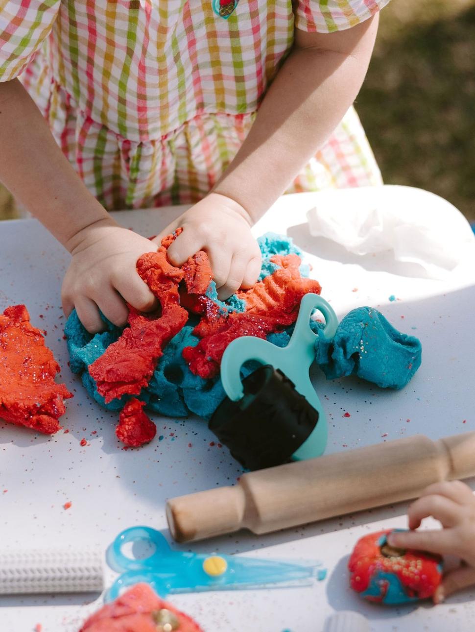 close up of child hands playing with play doh