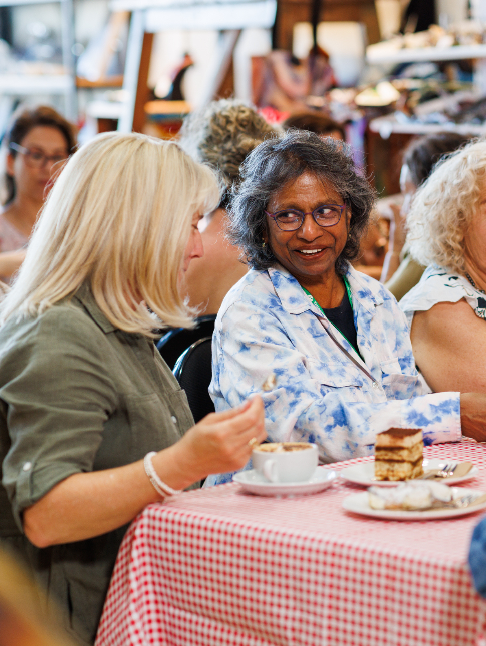 Two ladies talking enjoying a coffee and cake
