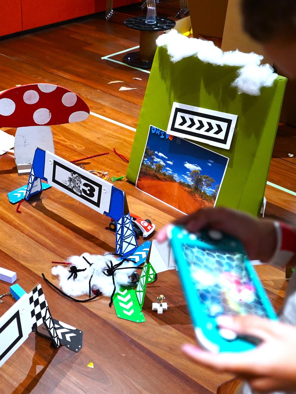 playing nintendo switch with handmade race track in the background