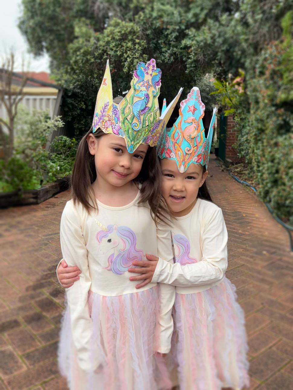 two children are wearing sea crown hats they crafted 