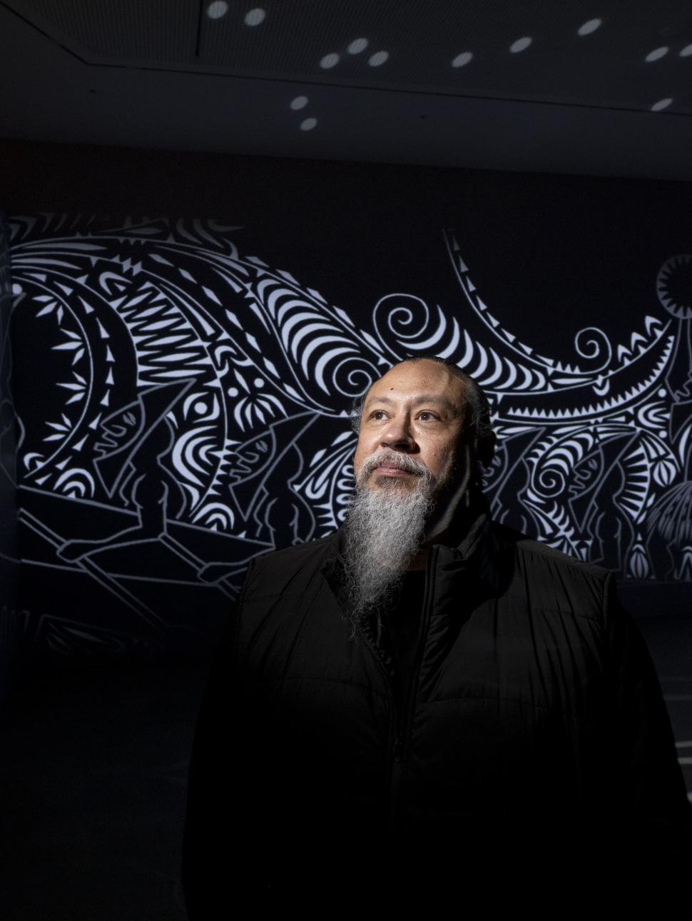 Photo of Brian Robinson in front of his artwork