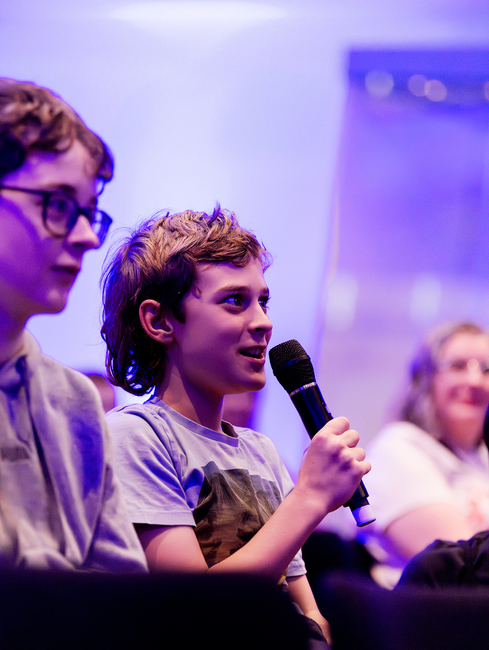 Kid holding a microphone at a talk