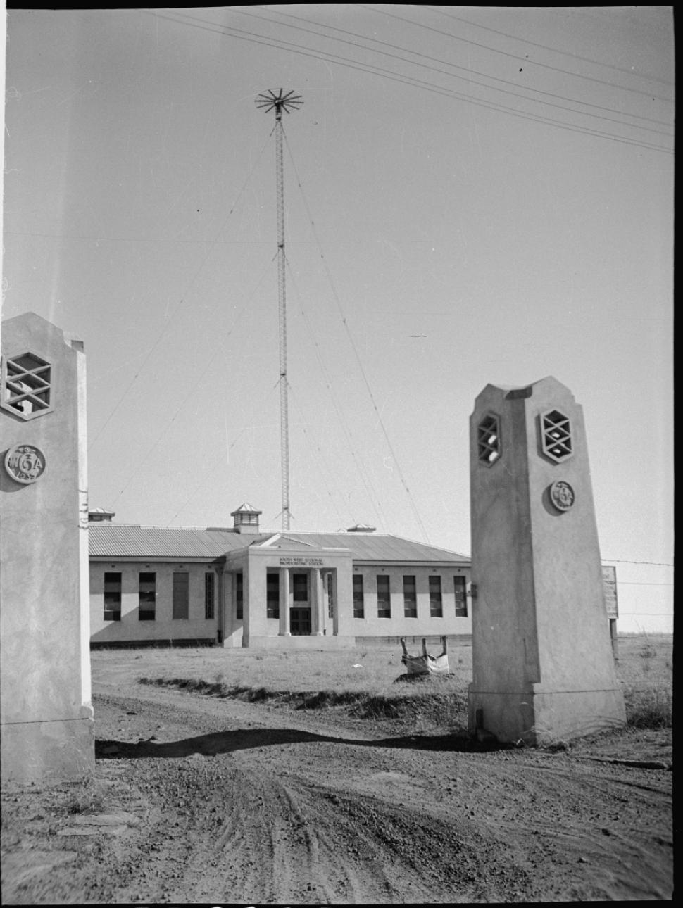 a black and white photo of a building with two pillars at the entrance 