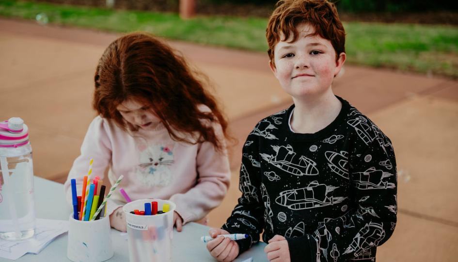 Photograph of a girl and a boy, aged 6, playing with space-themed crafts