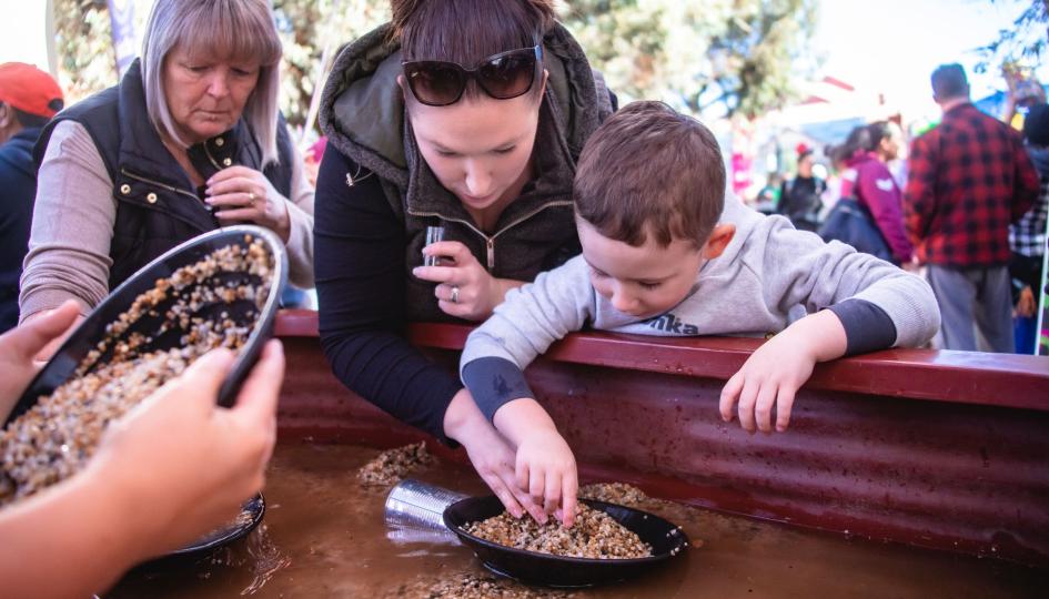 Mother and son shift through dirt to find gold