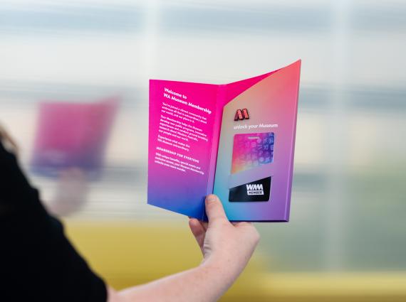 A person holds a Museum Membership package in their hand