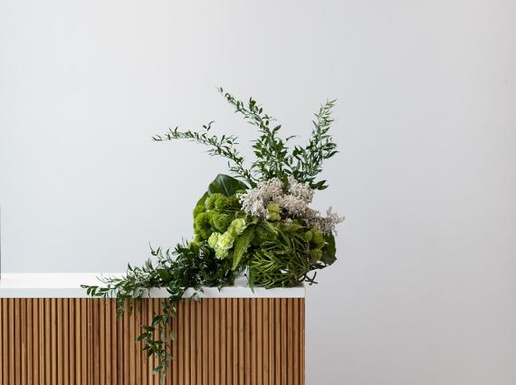 A bouquet of flowers displayed in front of a white wall
