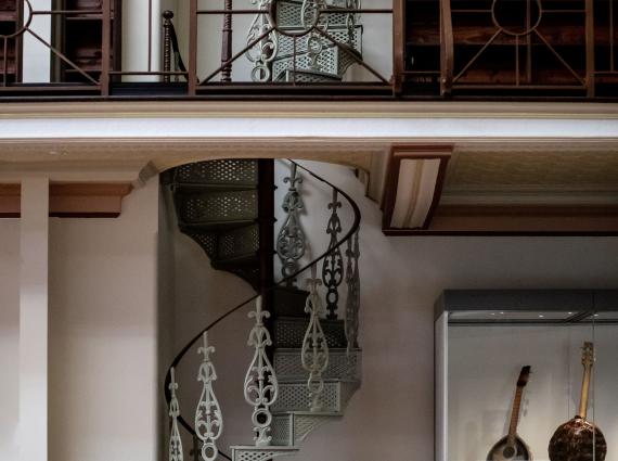 An old fashioned metal spiral staircase photographed across two levels