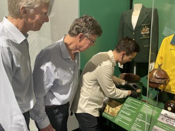 Three people observing a Museum display case 