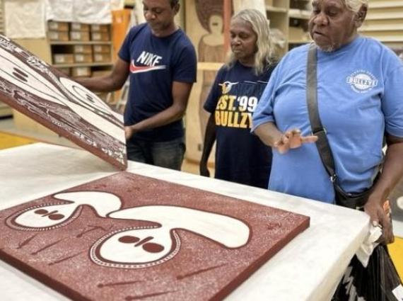 Kwini Traditional Owners observing cultural objects in a Museum setting