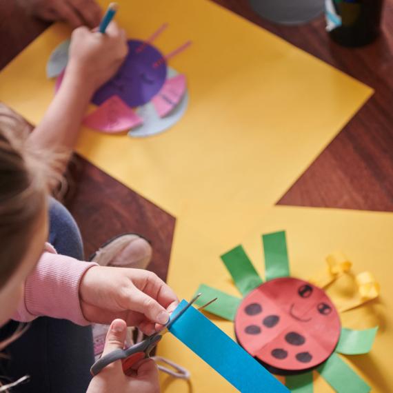 A child cutting out their own insect creation