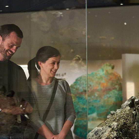 Two people looking at a mineral in the Origins gallery